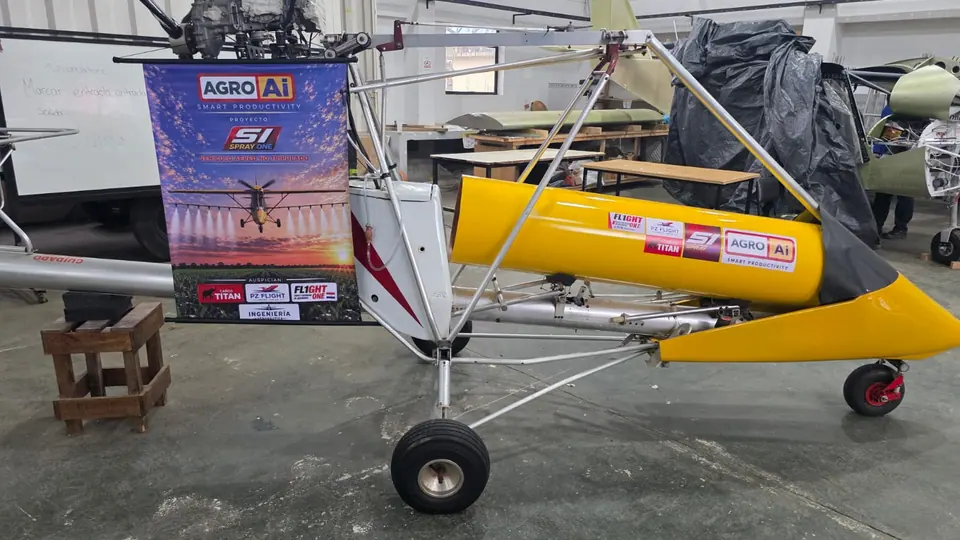 El prototipo con el tanque amarillo y los logos de AgroAI y Spray One, junto al afiche del proyecto